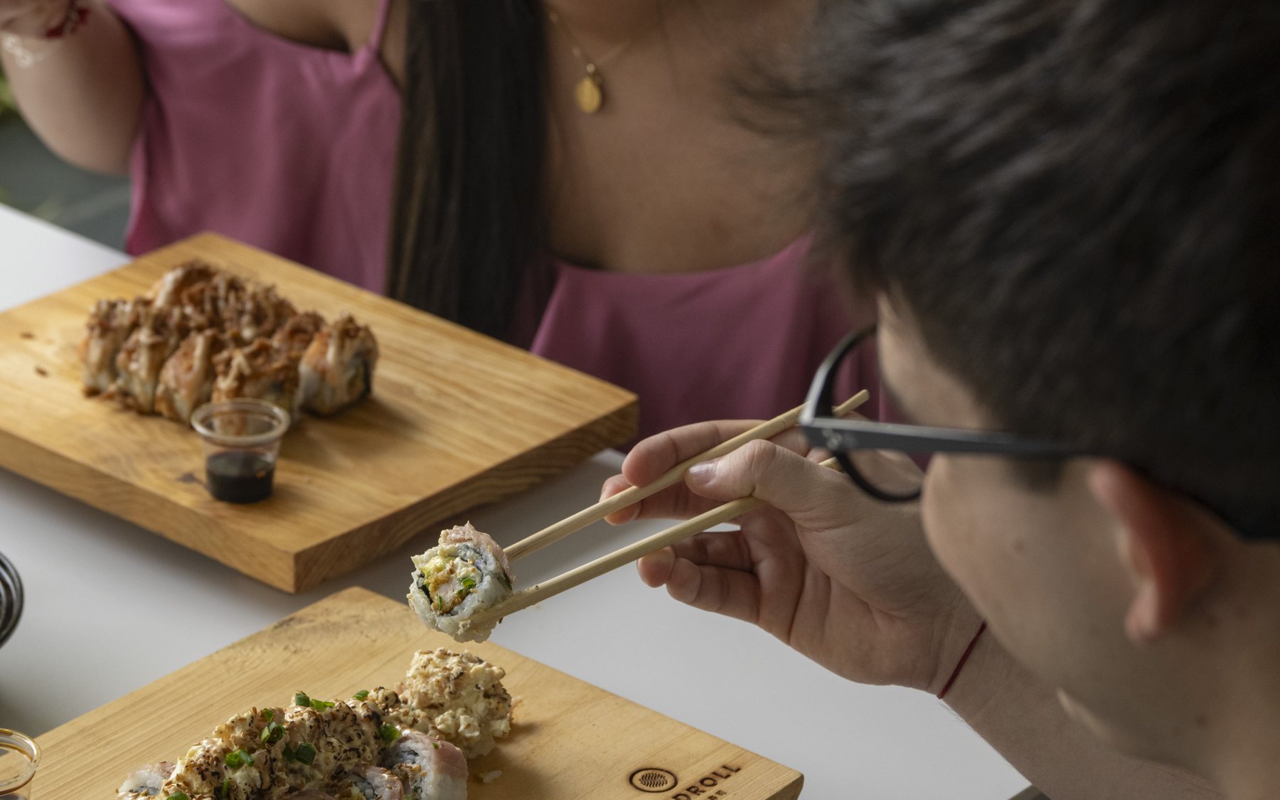 Dos personas comiendo sushi de Handroll en el Sambil Maracaibo